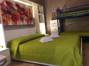 Un dormitorio con una cama verde con toallas. en Villa Tellina Mare Luna, en Granelli