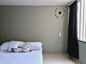een slaapkamer met een bed en een klok aan de muur bij Caobos 1212 in Girón