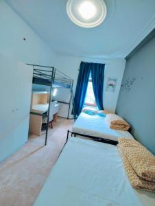 sypialnia z 2 łóżkami piętrowymi i oknem w obiekcie The ARK Eco Homestay w mieście Esch-sur-Alzette