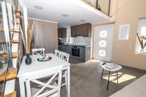 a kitchen and dining room with a white table and chairs at Zafeiropoulos Apartments in Marathopoli