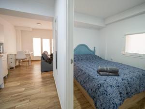 sypialnia z łóżkiem z niebieską narzutą w obiekcie Los Carros w mieście Cuenca