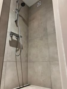 een douche met een douchekop in de badkamer bij Beach House met badkamer, boxspring & airco in Schoonebeek