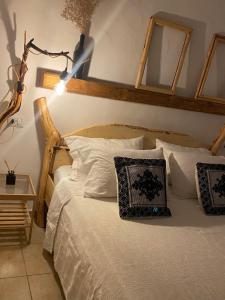 una camera da letto con letto, lenzuola e cuscini bianchi di I Ginepri a Teulada