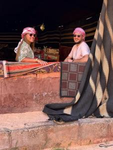 un hombre y una mujer sentados en una rampa de skate en Wadi Rum Meteor camp, en Wadi Rum