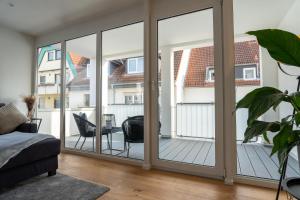 a living room with sliding glass doors at Schlossberg Residences: City-Apartment im Herzen der Bergstrasse in Bensheim
