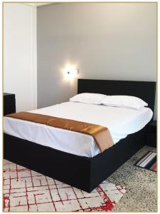 1 dormitorio con 1 cama grande con sábanas y almohadas blancas en Orange Guest Homes & Banquet Hall, en Serukele