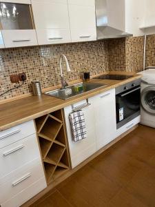 a kitchen with white cabinets and a sink at Апартамент “Djanina 2” in Sandanski
