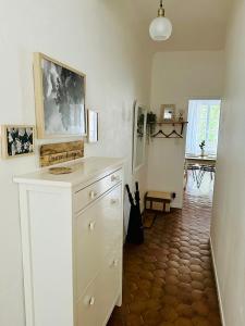 a kitchen with a white dresser in a room at "Douceur de vignes", cosy, coeur de ville, Classé 3 étoiles - BY PRIMO C0NCIERGERIE in Chalon-sur-Saône