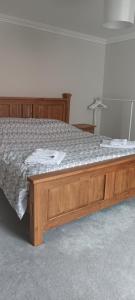 ein Bett mit einem Holzrahmen in einem Zimmer in der Unterkunft Eglinton Road - Super King - Private Bathroom in Bray