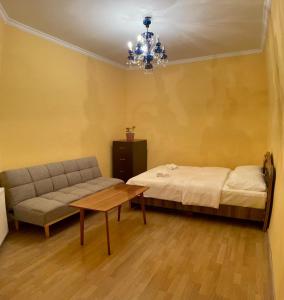 Cette chambre comprend un lit, un canapé et une table. dans l'établissement Apartment at Rustaveli avenue, near opera, à Tbilissi