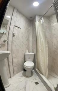 une salle de bain blanche avec toilettes et douche dans l'établissement Apartment at Rustaveli avenue, near opera, à Tbilissi