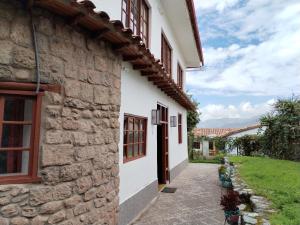 vista esterna di un edificio in pietra con finestre di El Jardín de Jeni a Cuzco