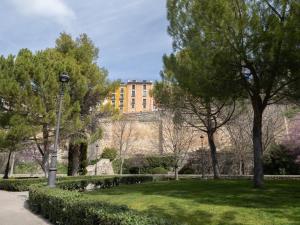 un parc avec un bâtiment en arrière-plan dans l'établissement Los Carros, à Cuenca