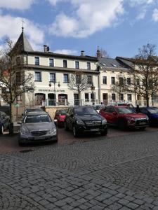 un grupo de coches estacionados frente a un edificio en Apartment Am Markt 4, en Bad Gottleuba