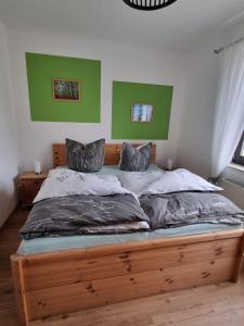 a bed in a bedroom with green and white walls at Ferienwohnung Cumbach in Rudolstadt