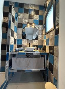 La salle de bains est pourvue d'un lavabo et d'un miroir. dans l'établissement Chambres d’hôtes Casarena, à Porto-Vecchio