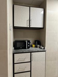 a kitchen with a microwave and a counter top at Palm Inn Hostel in Dubai