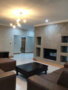 a living room with a fireplace and a couch at The 314 Euphoria Golf Estate in Naboomspruit