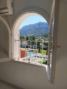 an arched window with a view of a pool at Studio tipo Loft con vista al Montgo in Denia
