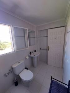 La salle de bains blanche est pourvue de toilettes et d'un lavabo. dans l'établissement Studio tipo Loft con vista al Montgo, à Dénia