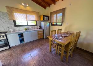 a kitchen with a wooden table and a refrigerator at Complejo La Dorada in Merlo