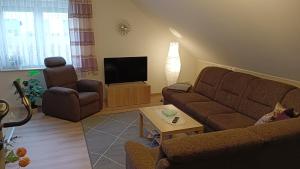 a living room with a couch and a tv at Ferienwohnung Schwedt Kastanienhöfe in Schwedt