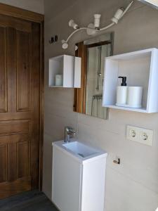 a bathroom with a sink and a mirror at Alojamiento Rural El ROMERO in Sabiote