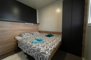 a bedroom with a bed with blue towels on it at Mobile home Mariola in Sveti Petar