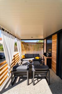 a patio with two beds and a table on a deck at Mobile home Mariola in Sveti Petar