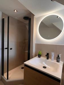 a bathroom with a sink and a shower with a mirror at 3 Zimmer Apartment mit Parkplatz - Sleepomat in Aschaffenburg