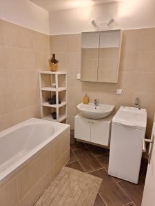 a bathroom with a tub and a sink at Flataid Apartments Ludersdorf - voll ausgestattet mit Parkplatz 