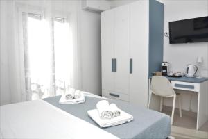 a white bedroom with a bed and a desk at Seaway Accommodation " Private Parking " in Tropea