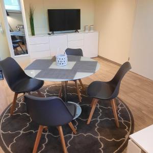 a table and four chairs in a living room at Theunis Ferienwohnung in Ostseebad Karlshagen
