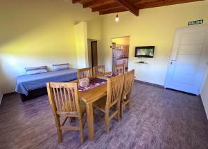 a dining room with a table and chairs and a bed at Complejo La Dorada in Merlo