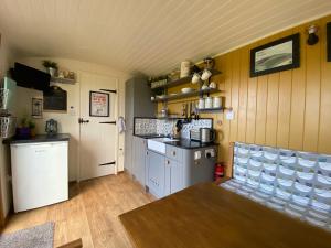 a kitchen with a counter and a table in a room at Shepherds Hut in the Hills - Nr. Mold in Nannerch