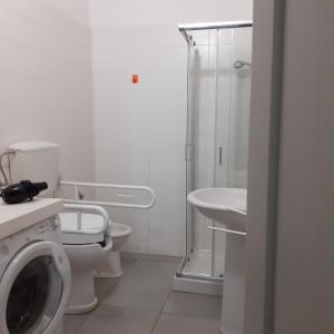 bagno bianco con servizi igienici e lavandino di Loft a Marconia a Marconia