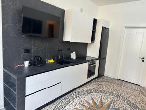 eine Küche mit weißen Schränken und einer schwarzen Arbeitsplatte in der Unterkunft Mosaic Inn in Genua