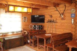 a dining room with a table and a tv in a cabin at Приватна садиба Дикий Мед in Ploskoye