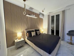 une chambre avec un lit et une table de chevet avec des lampes dans l'établissement Appartement vue mer vue Monaco, à Beausoleil