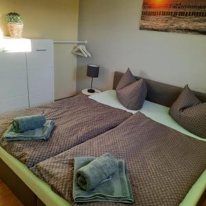 1 dormitorio con 1 cama con toallas en Theunis Ferienwohnung, en Ostseebad Karlshagen