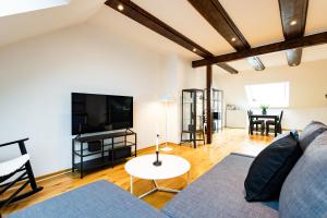 a living room with a couch and a tv at Exklusive Apartments in Kieler City in Kiel