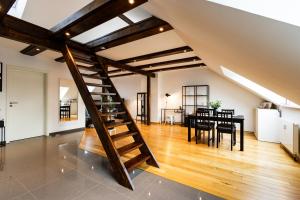 a loft with a wooden staircase and a dining room at Exklusive Apartments in Kieler City in Kiel