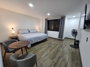 a bedroom with a bed and a table and chairs at Estancia Real in Morelia