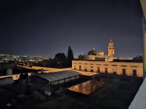a view of a building with a clock tower at night at Estancia Real in Morelia