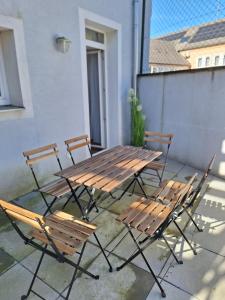 a wooden table and chairs on a patio at Flataid Apartments Ludersdorf - voll ausgestattet mit Parkplatz in Ludersdorf