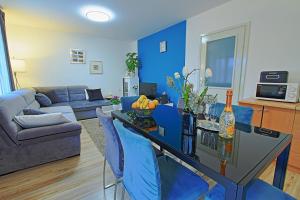 a blue living room with a table and blue chairs at Holiday Home Sinac in Sinac