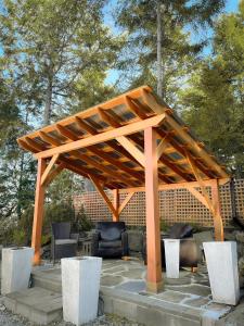 a wooden pergola sitting on a patio at Armand Heights in Ganges