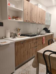 eine Küche mit Holzschränken und einem Tisch in der Unterkunft Salento Prestige B&B in Martano