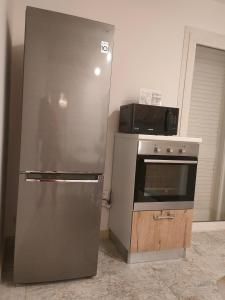 eine Küche mit einem Kühlschrank aus Edelstahl und einer Mikrowelle in der Unterkunft Salento Prestige B&B in Martano