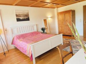 a bedroom with a white bed and a wooden floor at Haus Bergblick in Rettenberg